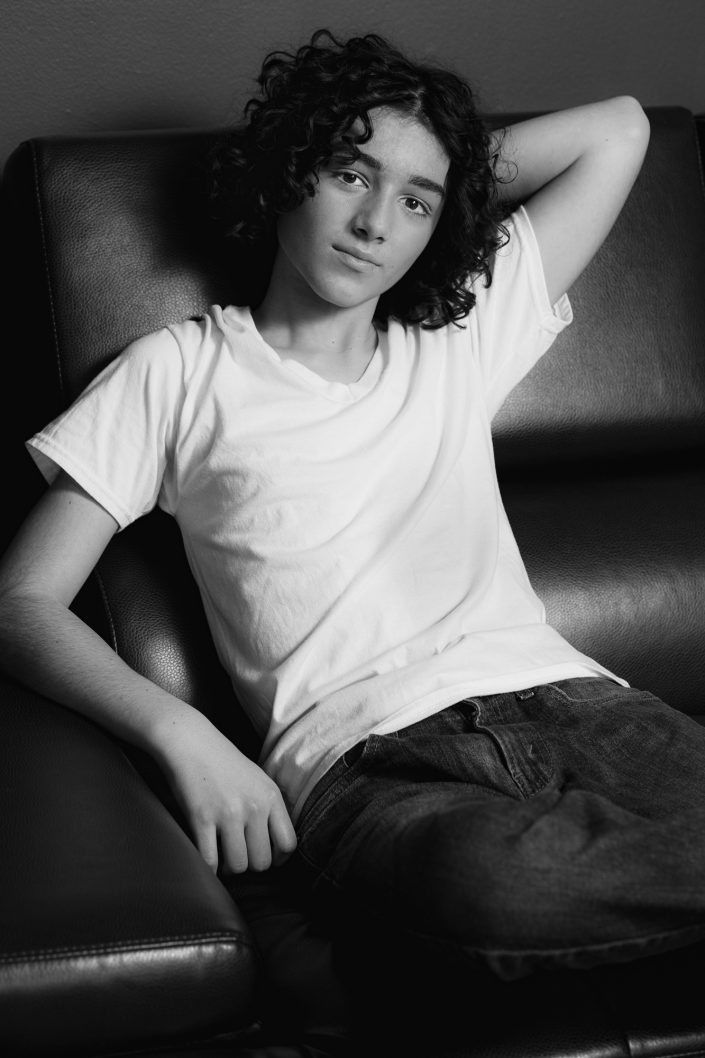 Teenage actor Christian wearing white t-shirt relaxing on couch in studio, black and white, 019A0230
