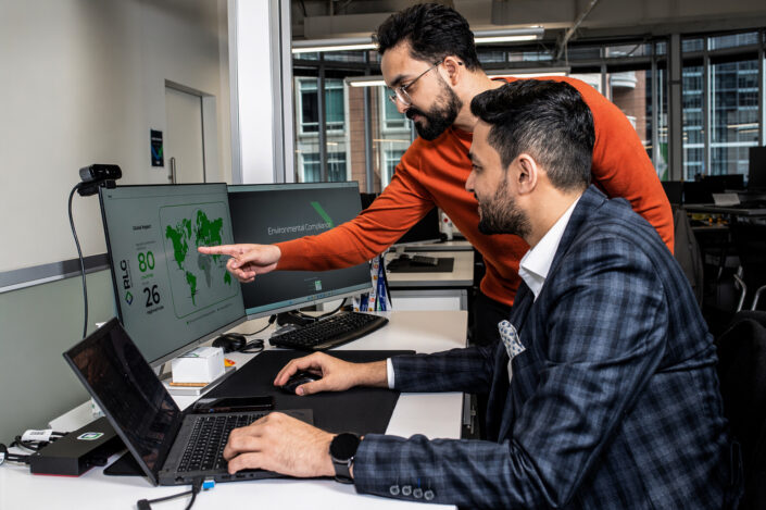 corporate photograph of RLG team members reviewing environmental compliance data in Toronto office